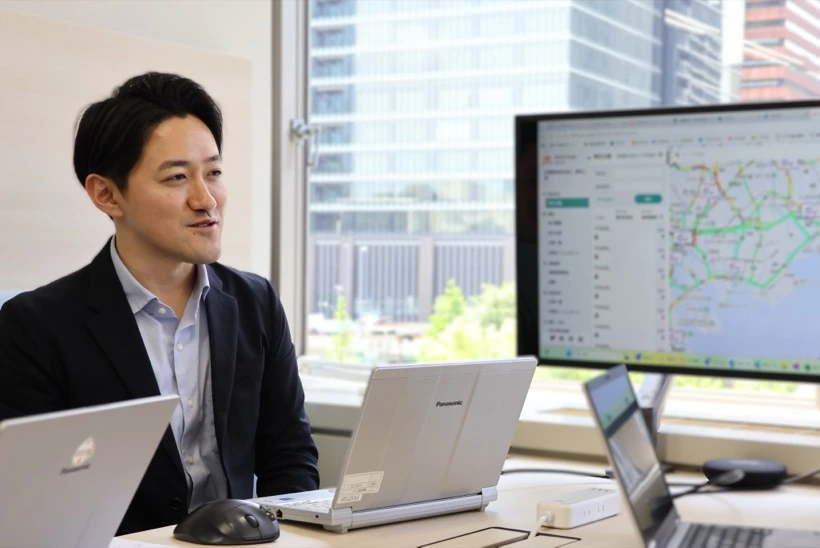 オフィスでシステム画面を確認しながら作業するM.Y