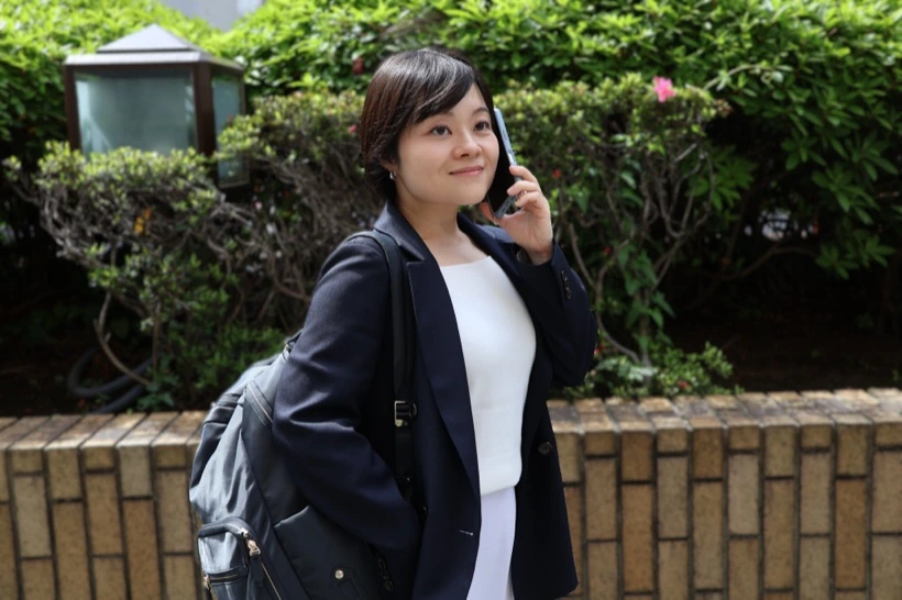 外出先で電話をしながら移動するH.M